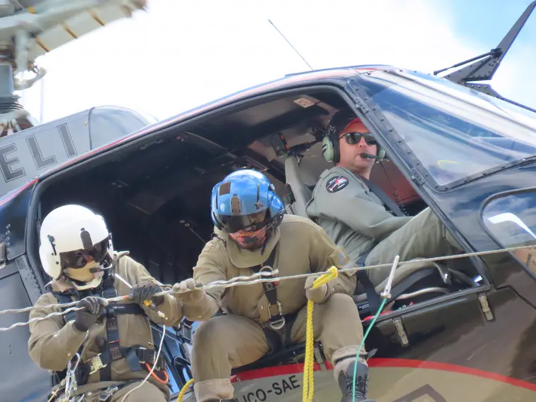 Equipe em operação aérea sobre linha de transmissão.